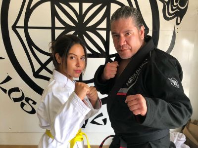Cinthya Carmona and Alexander Richard Mesquita are posing in a fighting stance.